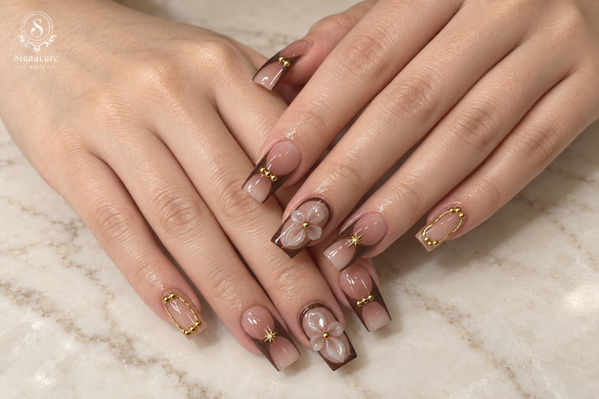 Glossy nude and brown square nails with gold beads and dimensional flower art